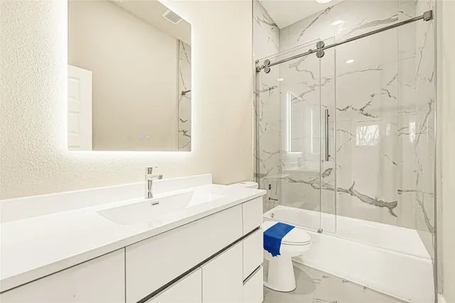 a bathroom with a sink mirror toilet and bathtub