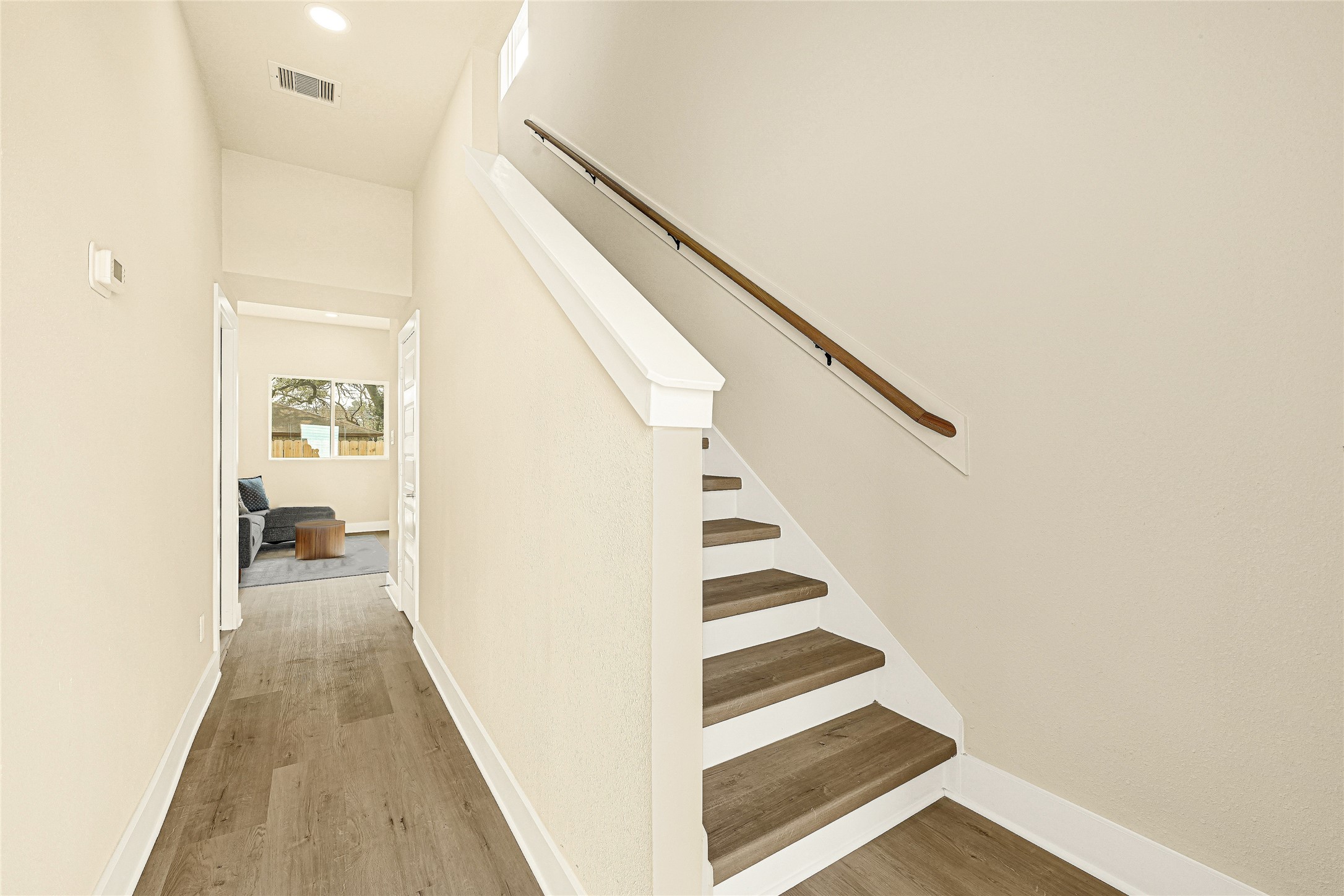 706 Savonna Houston, TX 77076 - Photo 2 of 26 a view of a hallway with wooden floor and staircase