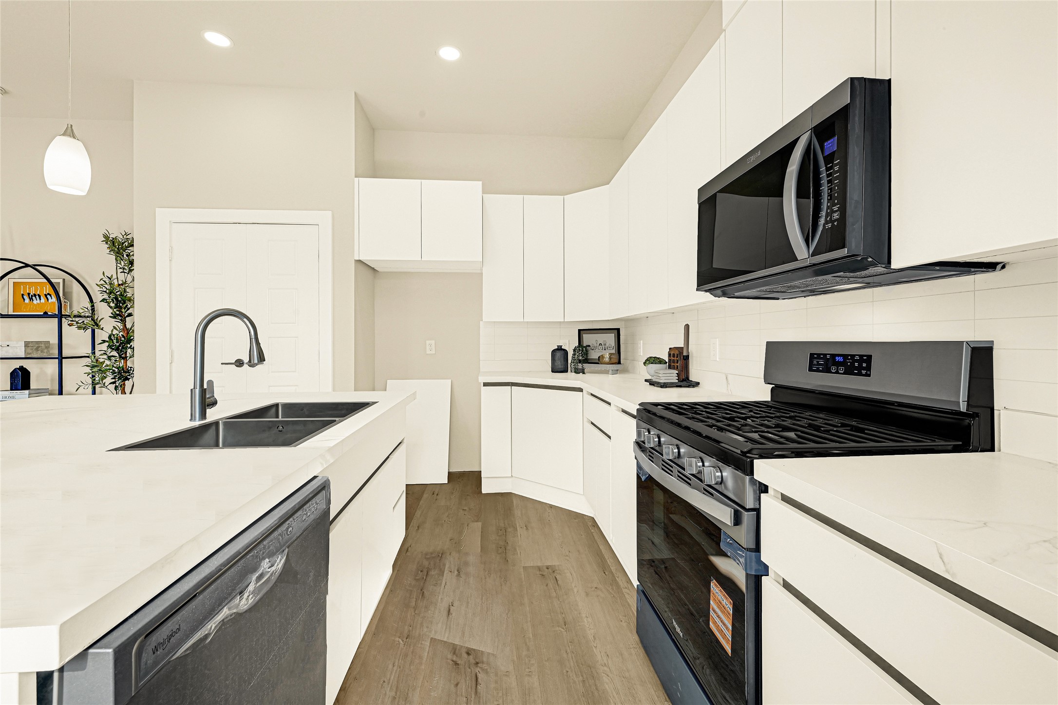 706 Savonna Houston, TX 77076 - Photo 8 of 26 a kitchen with stainless steel appliances granite countertop a stove top oven a sink dishwasher and white cabinets with wooden floor