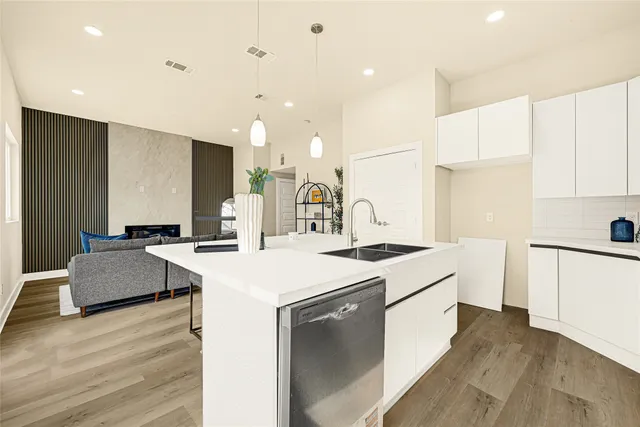 a kitchen with a sink a stove a refrigerator and white cabinets