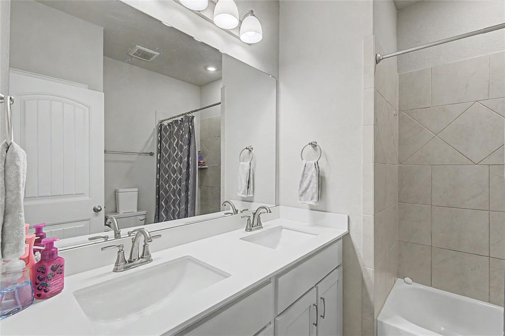 185 Chester Road Springtown, TX 76082 - Photo 30 of 40 Bathroom featuring a double vanity with white countertops, undermount sinks, and brushed nickel faucets