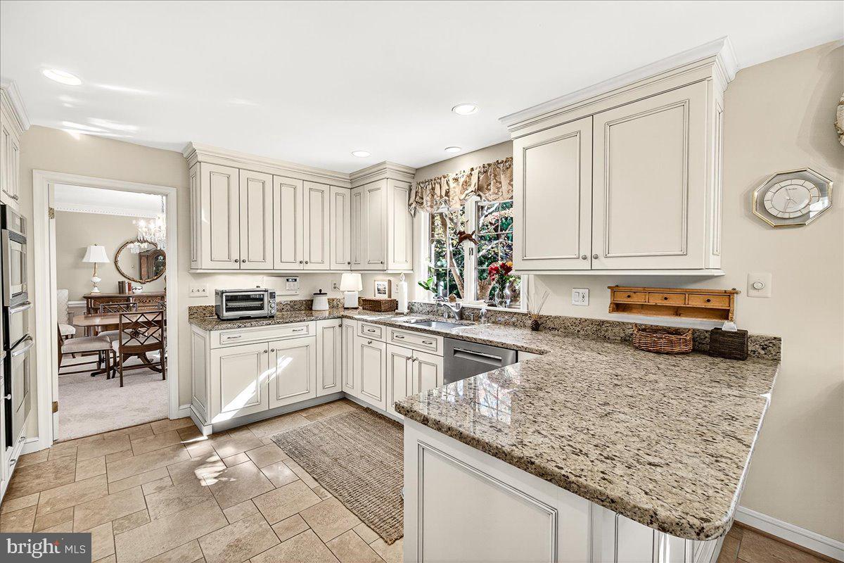 6400 Griffith Road Gaithersburg, MD 20882 - Photo 21 of 70 a kitchen with granite countertop a stove sink and cabinets