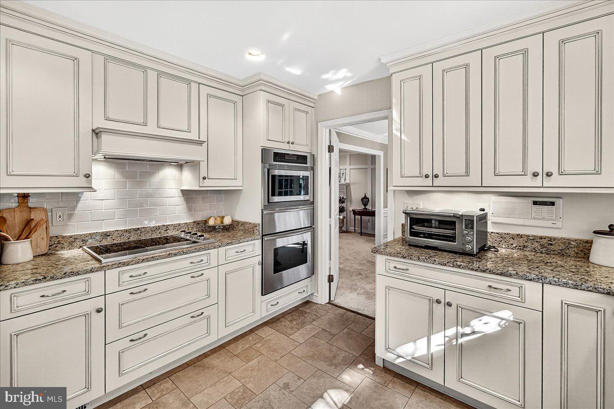 6400 Griffith Road Gaithersburg, MD 20882 - Photo 22 of 70 a kitchen with stainless steel appliances granite countertop a stove a sink and a refrigerator