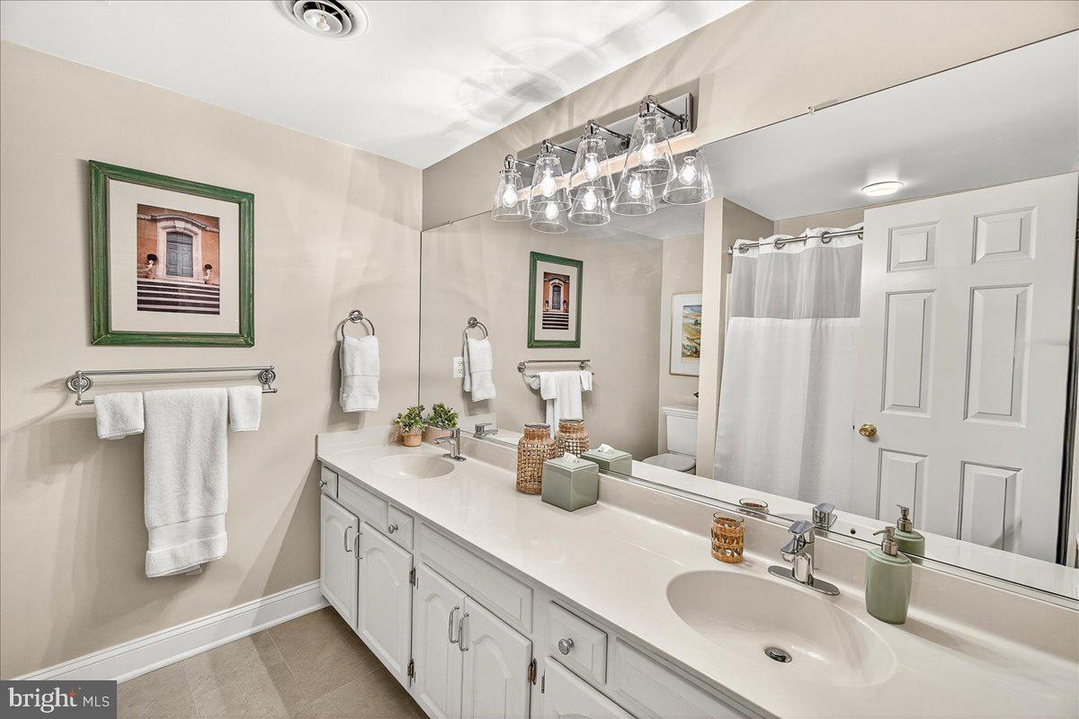 6400 Griffith Road Gaithersburg, MD 20882 - Photo 47 of 70 a bathroom with a double vanity sink and a mirror