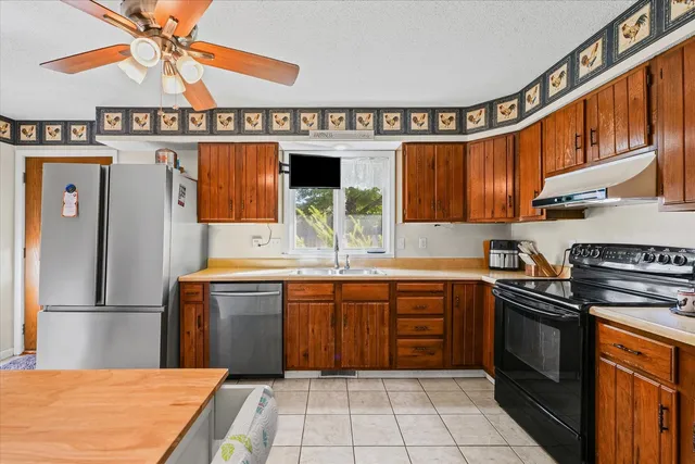 a kitchen with stainless steel appliances a sink stove and cabinets