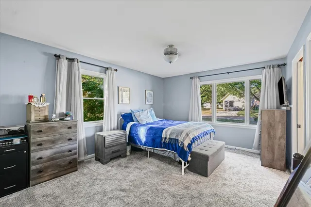 a bedroom with a bed and a flat tv screen on dresser
