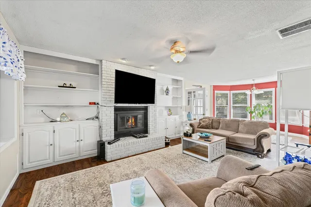 a living room with furniture wooden floor and a flat screen tv