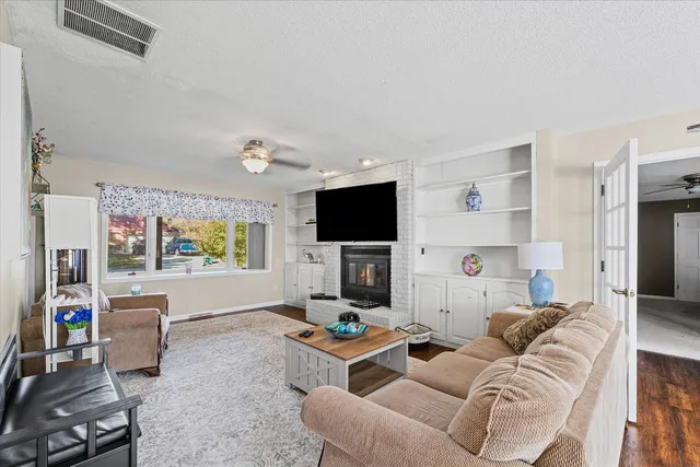 a living room with furniture a flat screen tv and a fireplace