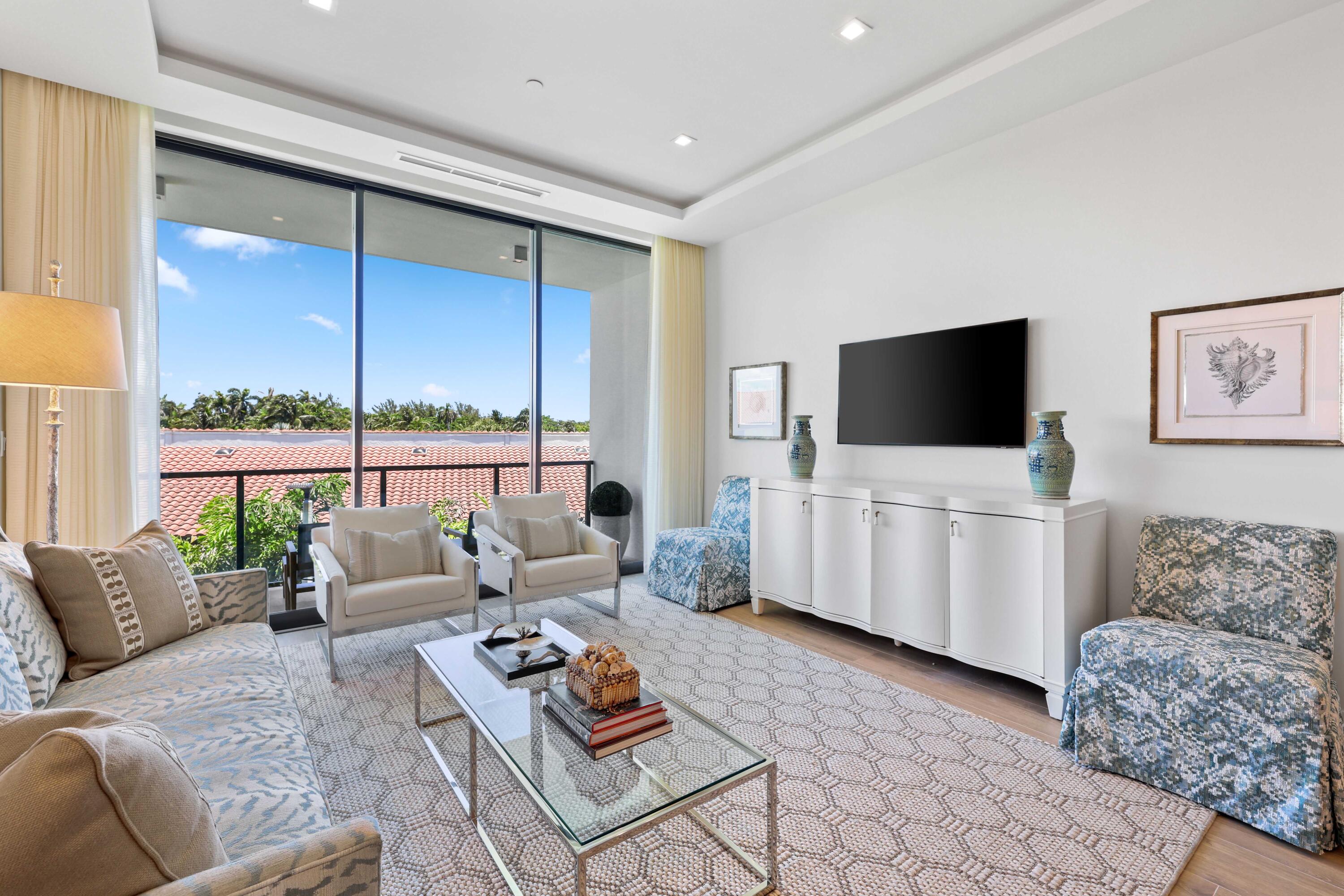 1177 George Bush Boulevard, Unit 306 Delray Beach, FL 33483 - Photo 19 of 66 a living room with furniture a flat screen tv and a floor to ceiling window
