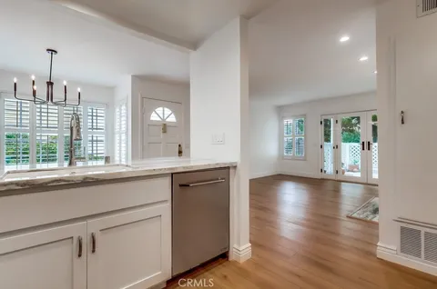 a view of a kitchen sink and wooden floor