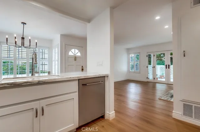 a view of a kitchen sink and wooden floor