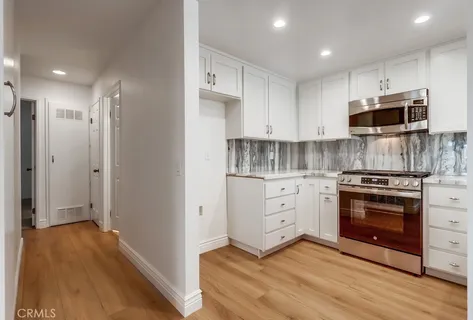 a kitchen with stainless steel appliances a stove a sink and a microwave