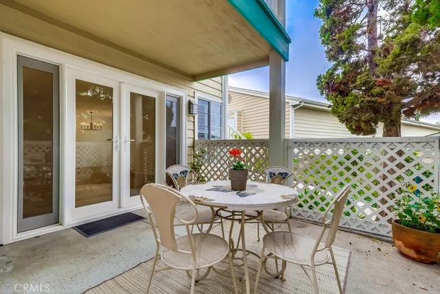 a view of a patio with a table and chairs and potted plants
