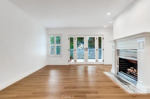 an empty room with wooden floor and fireplace