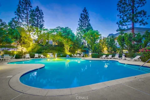 a view of a swimming pool with a yard and trees