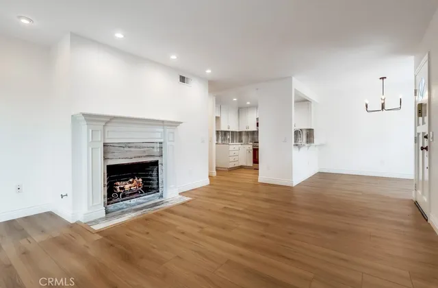 a view of empty room with wooden floor and fireplace