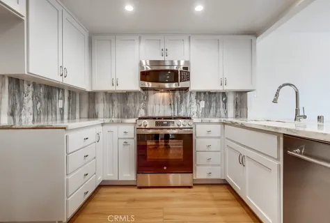 a kitchen with white cabinets and appliances