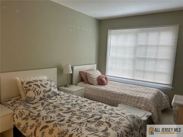 a large bed sitting in a bedroom next to a window