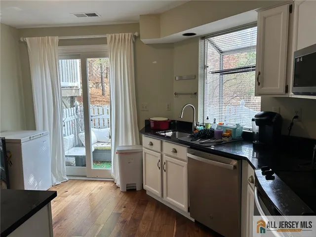 a kitchen with a sink appliances cabinets and a window
