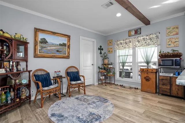 a kitchen with stainless steel appliances granite countertop a stove top oven a sink dishwasher a dining table and chairs with wooden floor