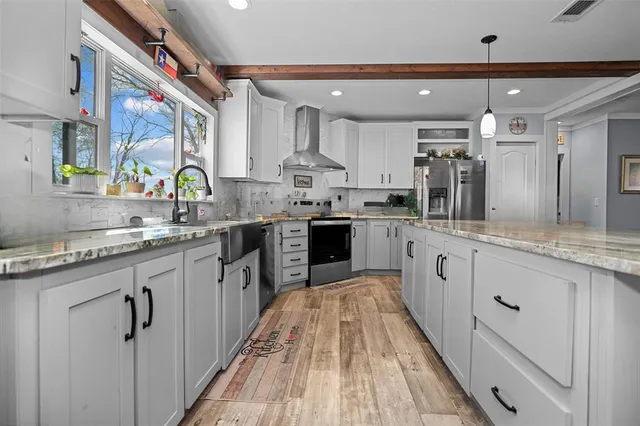 a kitchen with stainless steel appliances a sink stove and cabinets