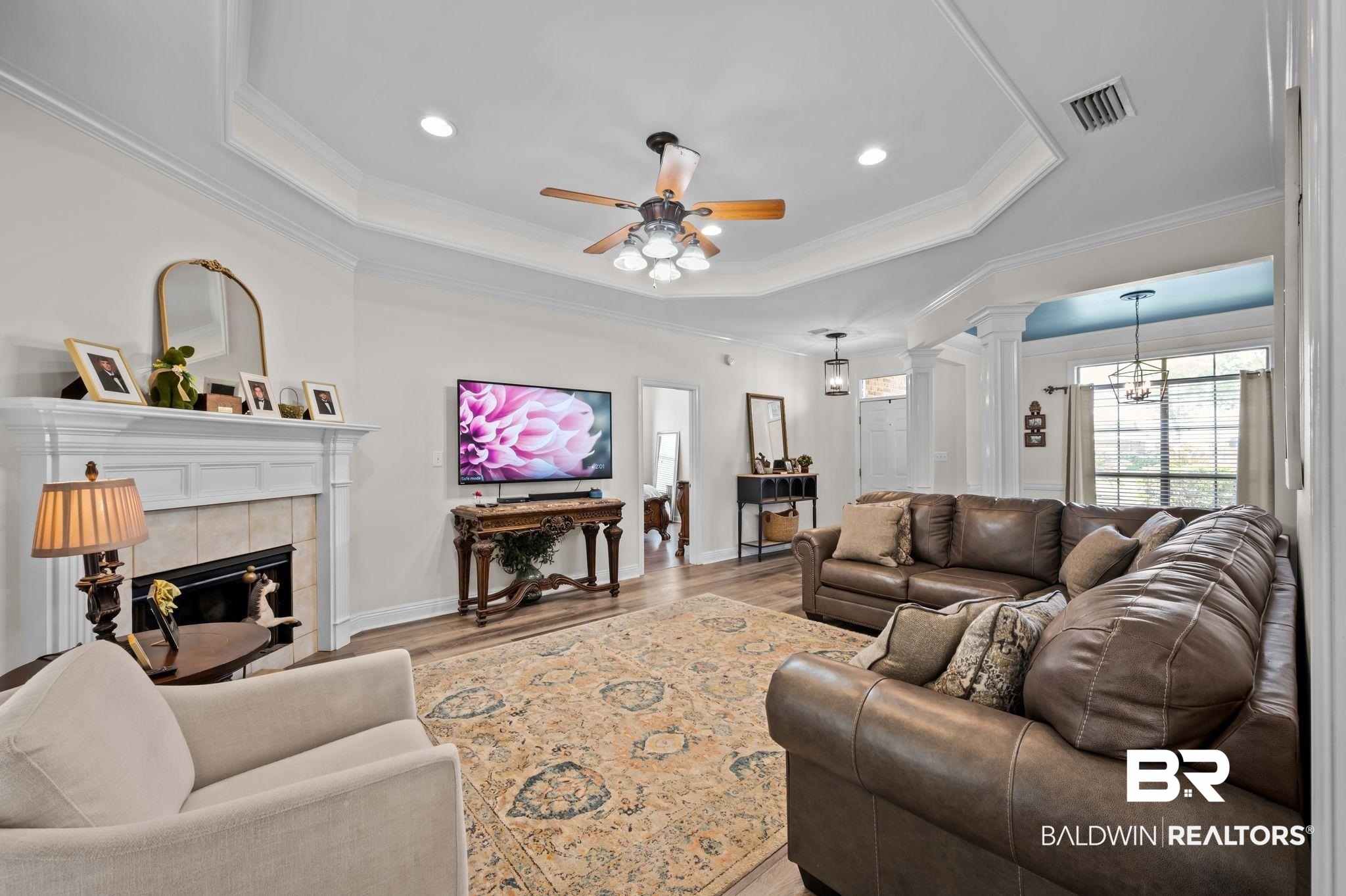 9837 Harmony Ridge Drive Semmes, AL 36575 - Photo 9 of 29 Living area featuring a tray ceiling, decorative columns, wood finished floors, ceiling fan, and ornamental molding