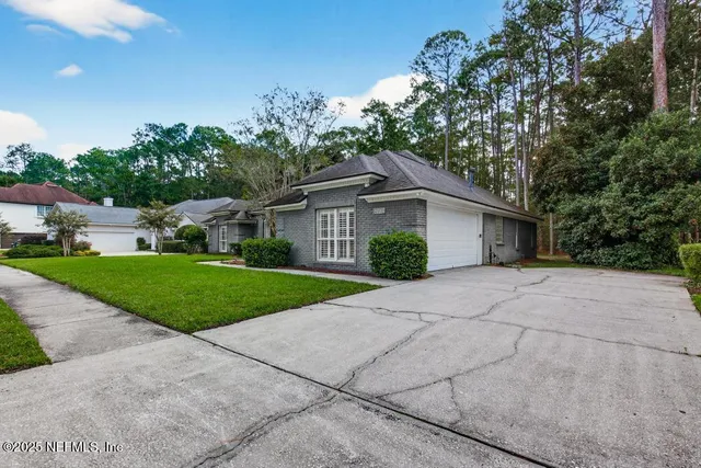 a front view of a house with a yard and trees
