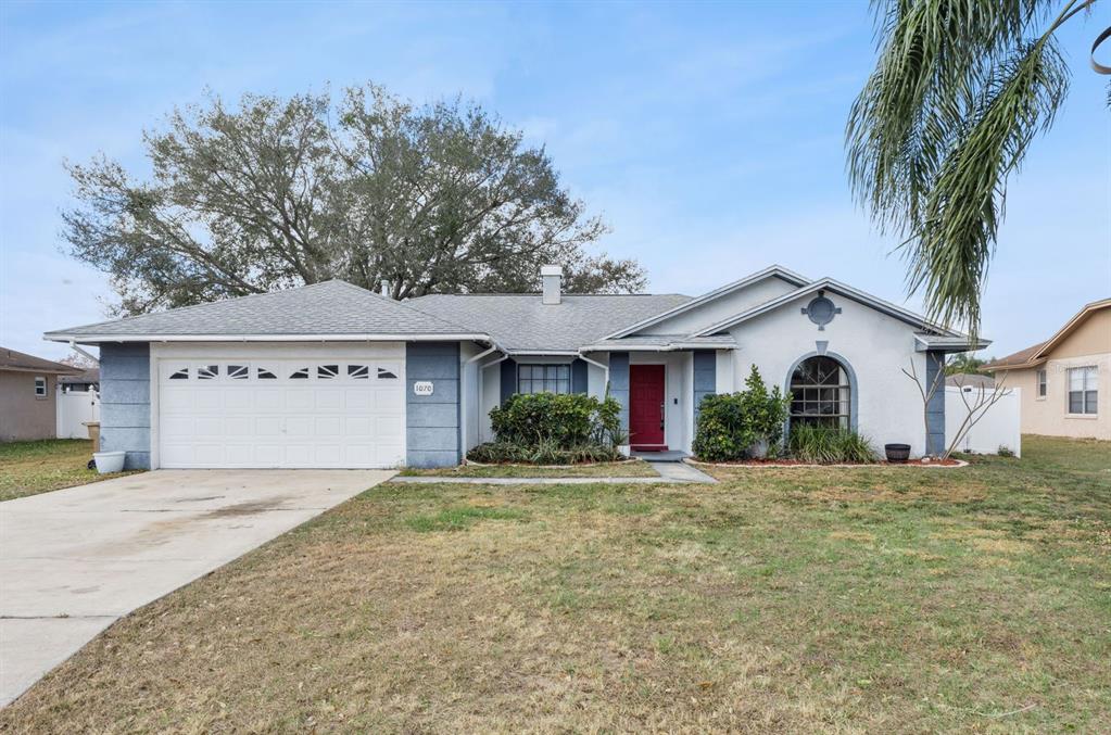 1070 Hali Ridge Court Kissimmee, FL 34747 - Photo 1 of 36 a front view of a house with a yard and garage