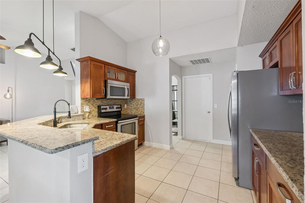 1070 Hali Ridge Court Kissimmee, FL 34747 - Photo 7 of 36 a kitchen with stainless steel appliances granite countertop a sink stove and refrigerator