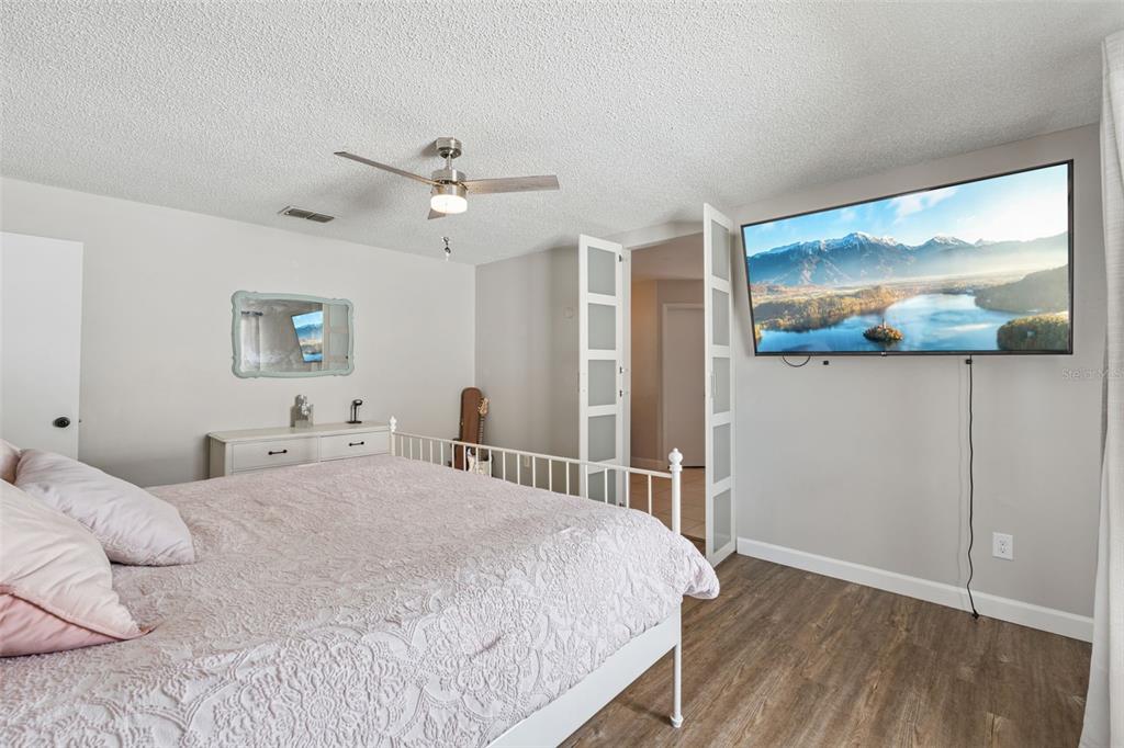 1070 Hali Ridge Court Kissimmee, FL 34747 - Photo 9 of 36 a bedroom with a large bed and a painting on the wall