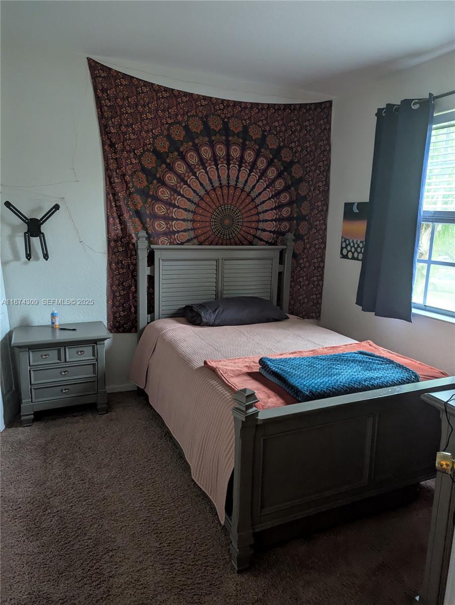 8496 Southwest 29th Street, Unit 104 Miramar, FL 33025 - Photo 15 of 19 a bedroom with a bed and a night stand