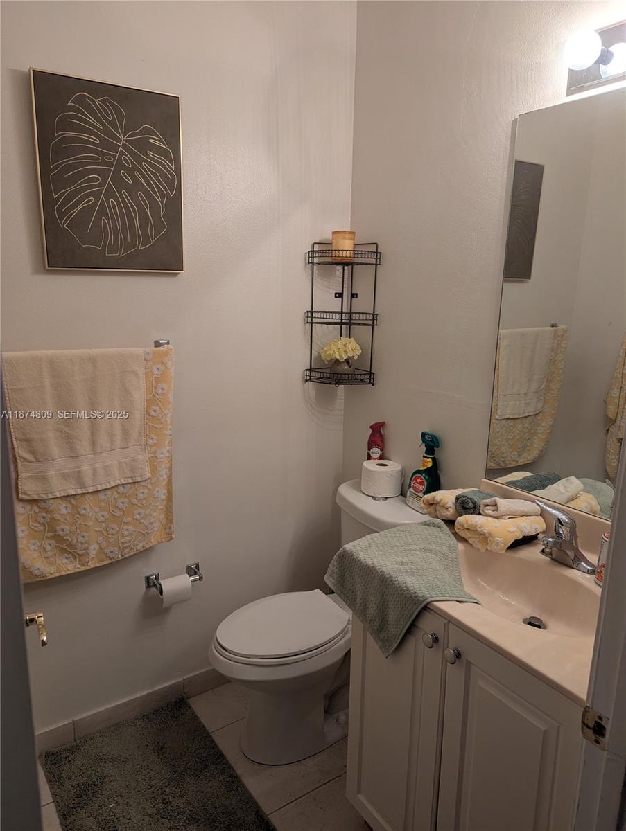 8496 Southwest 29th Street, Unit 104 Miramar, FL 33025 - Photo 3 of 19 a bathroom with a toilet sink and mirror