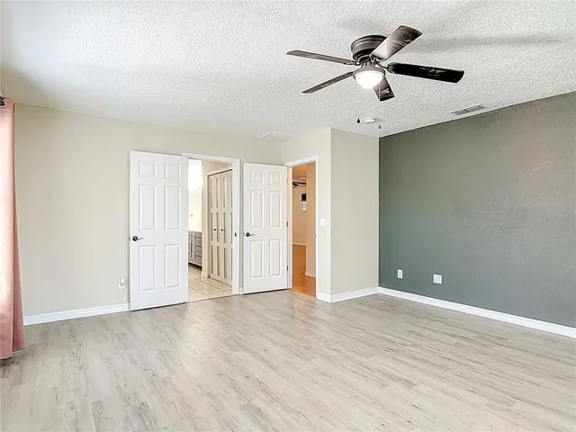 a view of a room with wooden floor and a ceiling fan