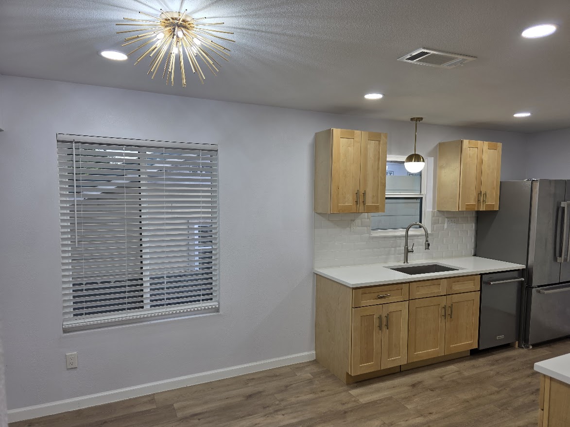 4803 Peach Grove Road Austin, TX 78744 - Photo 20 of 22 a kitchen with a sink cabinets and wooden floor