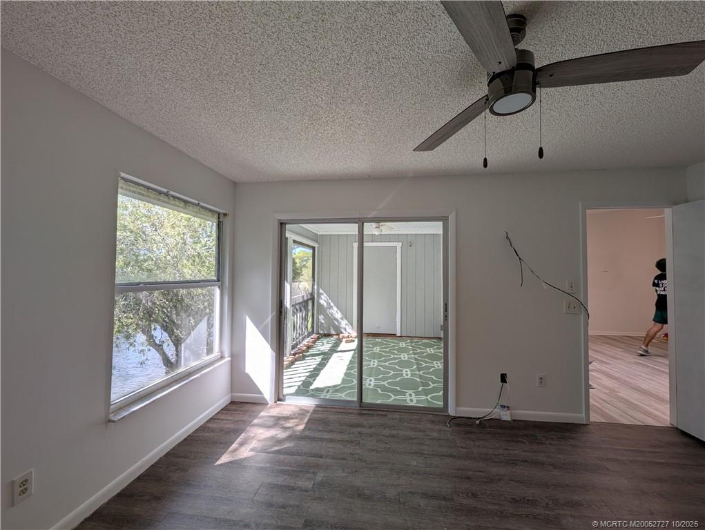 8291 Southeast Croft Circle, Unit M8 Hobe Sound, FL 33455 - Photo 11 of 22 a view of empty room with wooden floor and fan