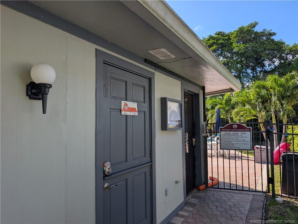 8291 Southeast Croft Circle, Unit M8 Hobe Sound, FL 33455 - Photo 18 of 22 a front view of a house with a tree
