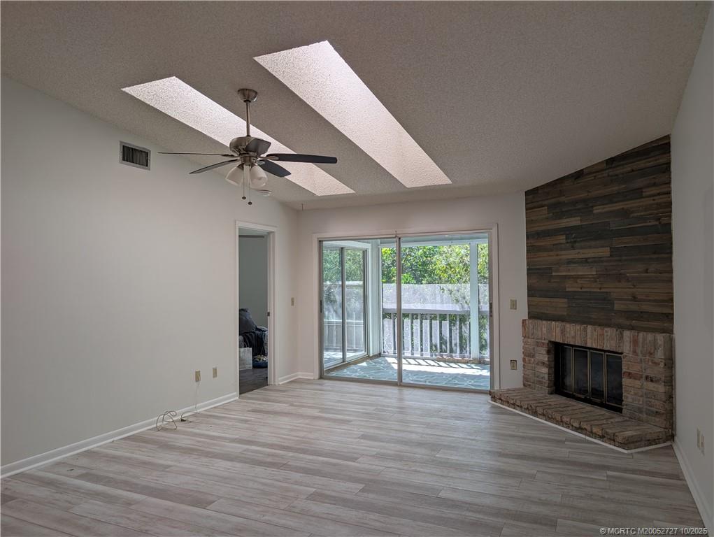 8291 Southeast Croft Circle, Unit M8 Hobe Sound, FL 33455 - Photo 5 of 22 a view of an empty room with wooden floor and a fireplace