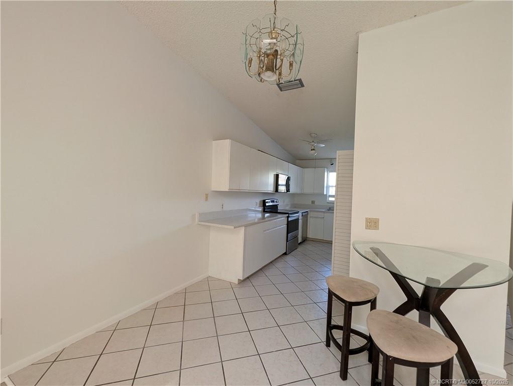 8291 Southeast Croft Circle, Unit M8 Hobe Sound, FL 33455 - Photo 7 of 22 a kitchen with a table and chairs in it