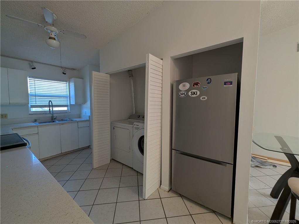 8291 Southeast Croft Circle, Unit M8 Hobe Sound, FL 33455 - Photo 9 of 22 a kitchen with a refrigerator sink and cabinets