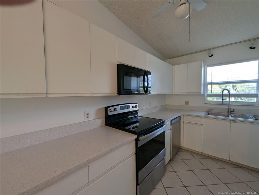 8291 Southeast Croft Circle, Unit M8 Hobe Sound, FL 33455 - Photo 10 of 22 a kitchen with a sink stove and microwave