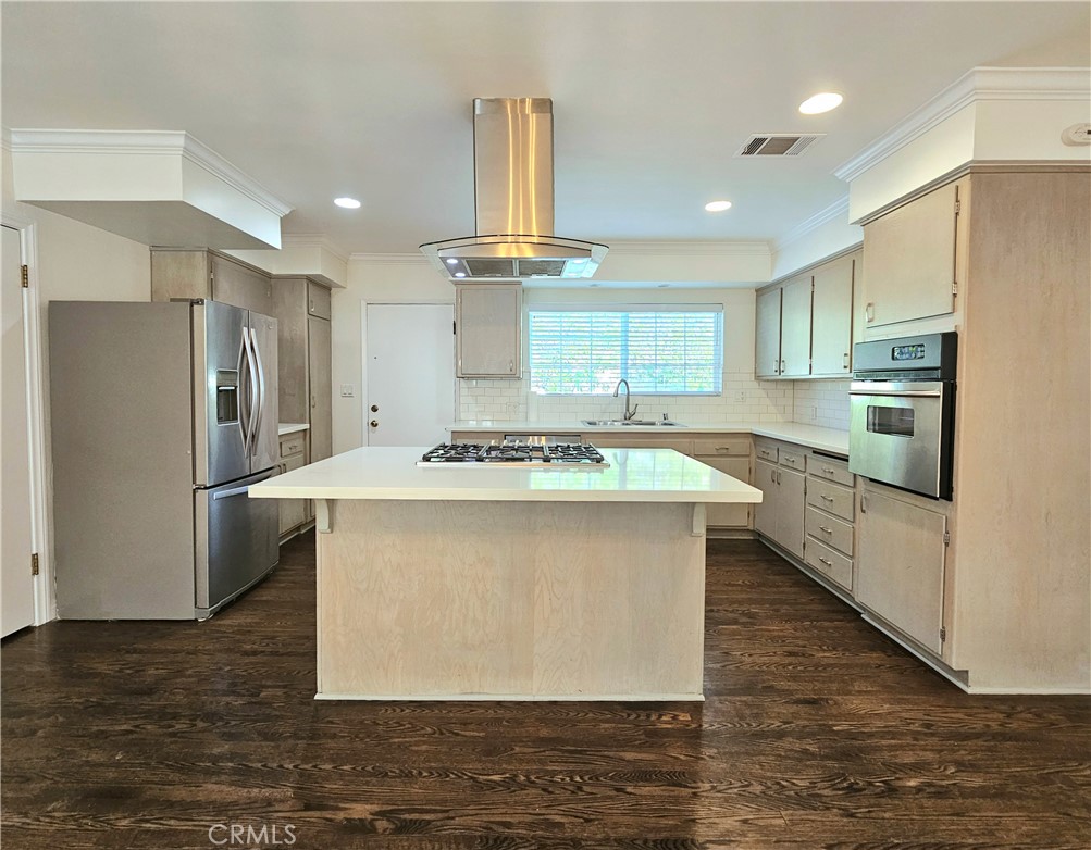 17501 Hamlin Street Lake Balboa, CA 91406 - Photo 7 of 26 a kitchen with stainless steel appliances a refrigerator a sink dishwasher a stove and white cabinets with wooden floor