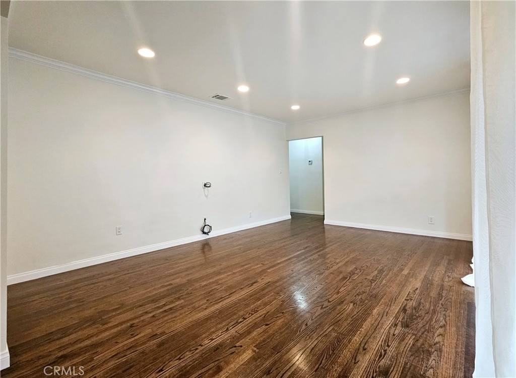 17501 Hamlin Street Lake Balboa, CA 91406 - Photo 9 of 26 an empty room with wooden floor and natural light