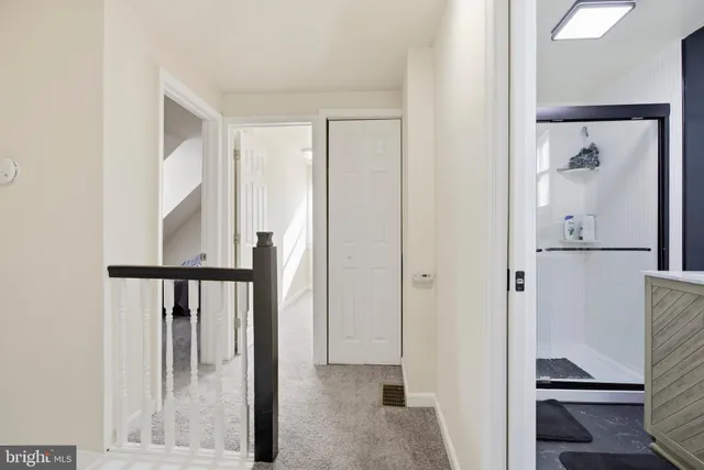 a view of a hallway with wooden floor and furniture