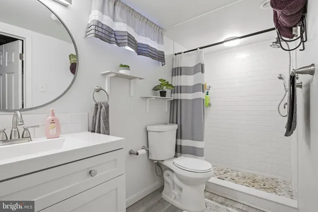 a bathroom with a sink a toilet and shower