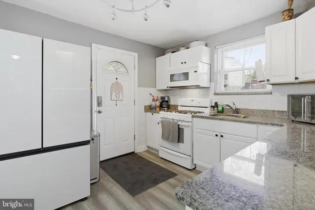 a kitchen with white cabinets and white appliances