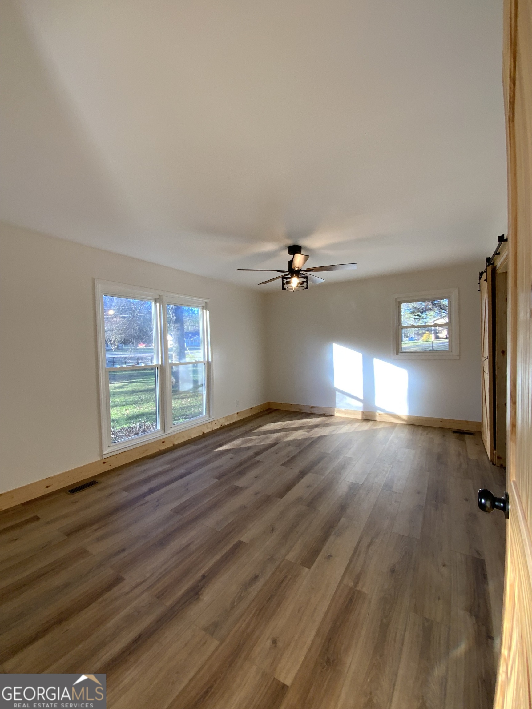 5569 Fosters Mill Road Cave Spring, GA 30124 - Photo 17 of 19 a view of empty room with wooden floor and fan