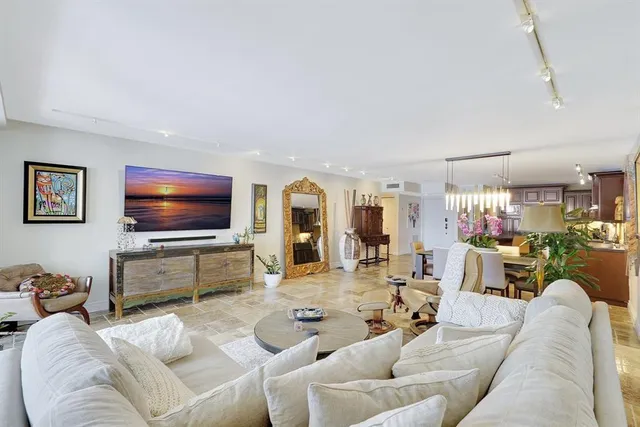 a living room with furniture a flat screen tv and a floor to ceiling window