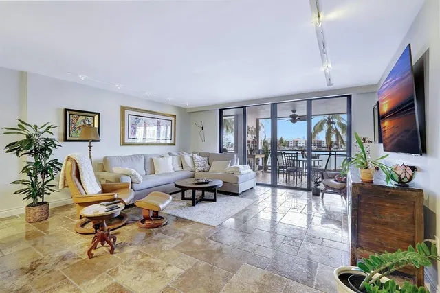 a living room with furniture kitchen view and a potted plant