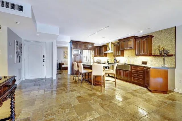 a kitchen with stainless steel appliances kitchen island granite countertop a sink and cabinets