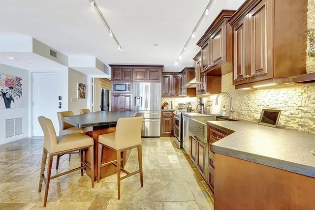 a living room with stainless steel appliances kitchen island granite countertop furniture and a kitchen view